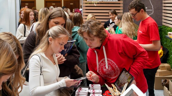 młodzież wraz z pracownikiem rekrutacji UwB podczas targ&oacute;w edukacyjnych Salon Maturzyst&oacute;w Perspektywy 2026