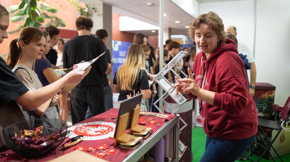 Pracownicy Uniwersyteckiego Centrum Rekrutacji rozmawiają z uczniami przy stoisku Uniwersytetu w Białymstoku podczas Białostockiego Salonu Maturzysty