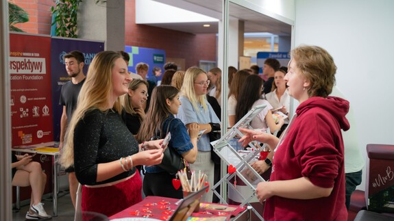 Pracownik Uniwersyteckiego Centrum Rekrutacji rozmawiają z uczniami przy stoisku Uniwersytetu w Białymstoku podczas Białostockiego Salonu Maturzysty
