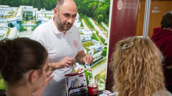 Pracownicy Uniwersyteckiego Centrum Rekrutacji rozmawiają z uczniami przy stoisku Uniwersytetu w Białymstoku podczas Białostockiego Salonu Maturzysty