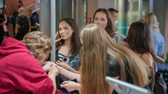 Pracownik Uniwersyteckiego Centrum Rekrutacji rozmawiają z uczniami przy stoisku Uniwersytetu w Białymstoku podczas Białostockiego Salonu Maturzysty