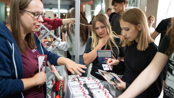 Pracownicy Uniwersyteckiego Centrum Rekrutacji rozmawiają z uczniami przy stoisku Uniwersytetu w Białymstoku podczas Białostockiego Salonu Maturzysty