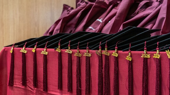 birety i gadżety na stole podczas uroczystości zakończenia programu tutorskiego w 2026 r.