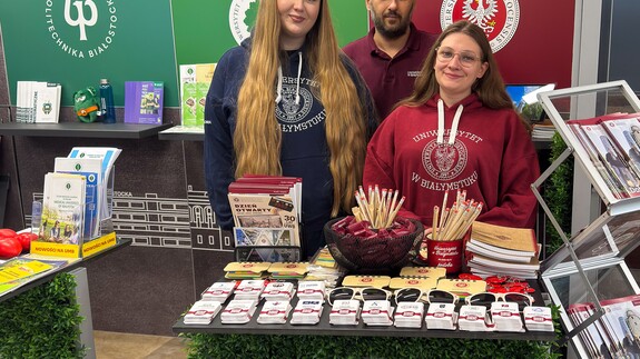 pracownik rekrutacji UwB wraz ze studentkami UwB przy stoisku