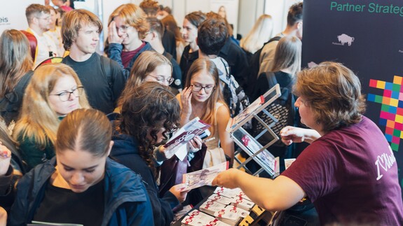 młodzież wraz z pracownikiem rekrutacji UwB podczas targ&oacute;w edukacyjnych Salon Maturzyst&oacute;w Perspektywy 2026